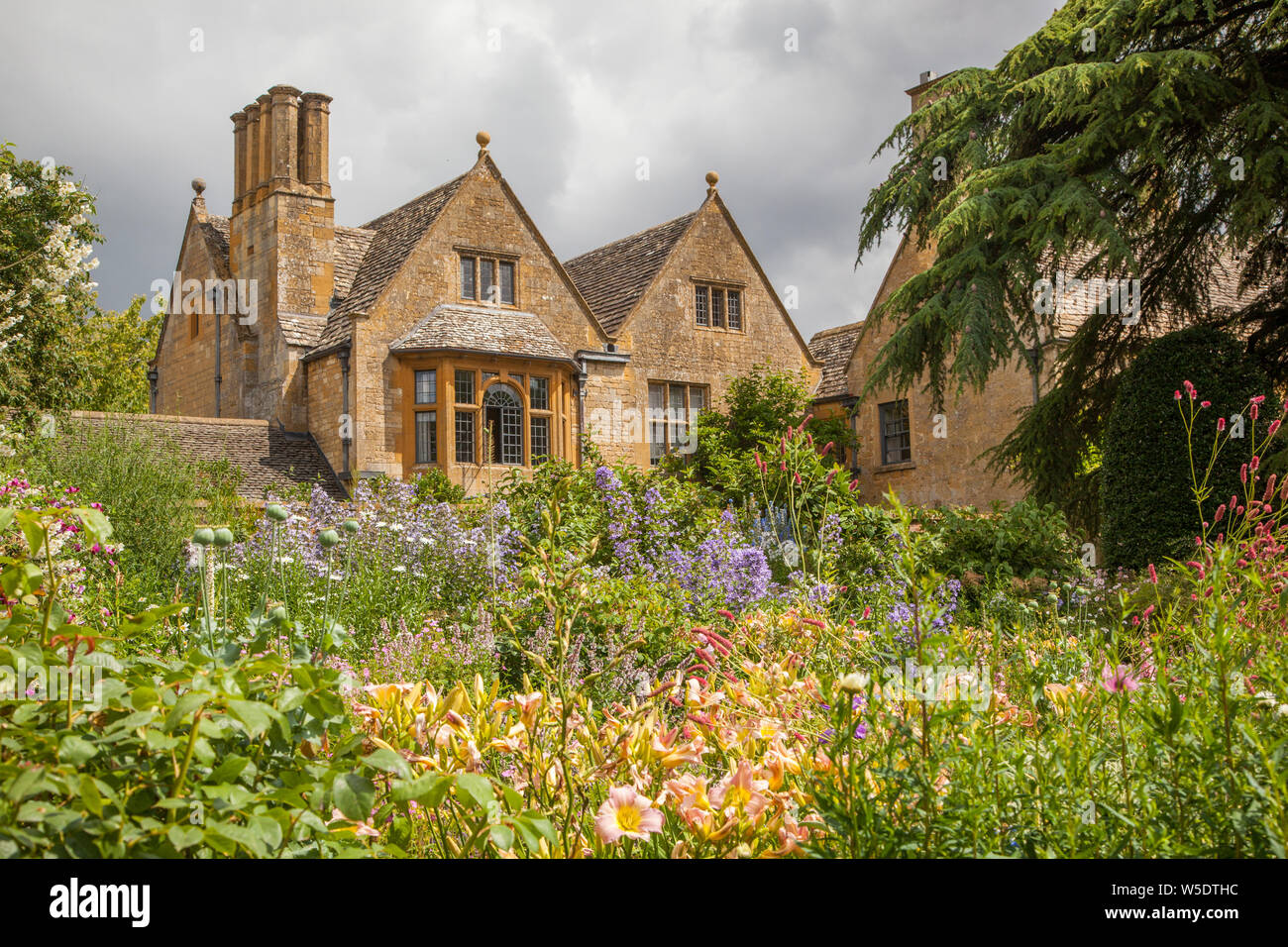 English Country House auf dem Gelände des National Trust Eigentum von Hidcote Manor Gardens mit ihren krautigen Blumenrabatten in den englischen Cotswolds Stockfoto English Country House auf dem Gelände des National Trust Eigentum von Hidcote Manor Gardens mit ihren krautigen Blumenrabatten in den englischen Cotswolds Stockfoto