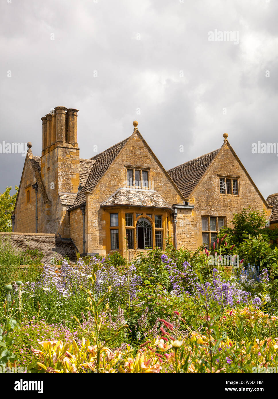 English Country House auf dem Gelände des National Trust Eigentum von Hidcote Manor Gardens mit ihren krautigen Blumenrabatten in den englischen Cotswolds Stockfoto English Country House auf dem Gelände des National Trust Eigentum von Hidcote Manor Gardens mit ihren krautigen Blumenrabatten in den englischen Cotswolds Stockfoto