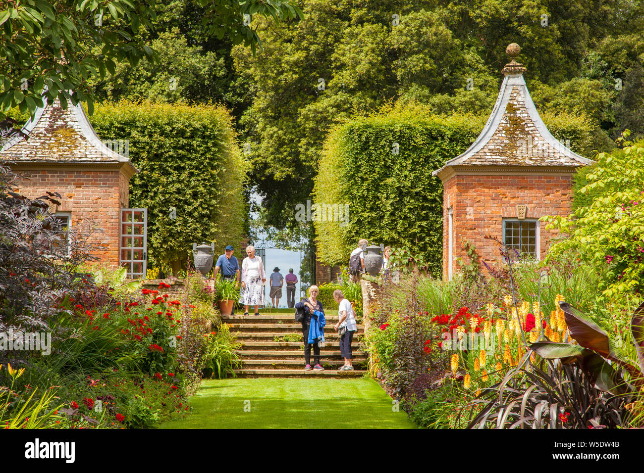 Die Menschen genießen den Tag in der National Trust Eigentum von Hidcote Manor Gardens mit ihren krautigen Blumenrabatten in den englischen Cotswolds Stockfoto