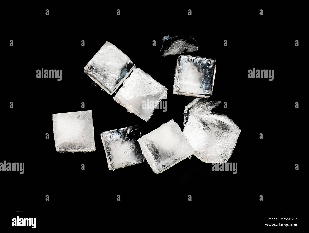 Würfel aus Eis isoliert auf schwarzen Hintergrund, Stücke von Crushed Ice mit Schnee auf der Oberseite Stockfoto