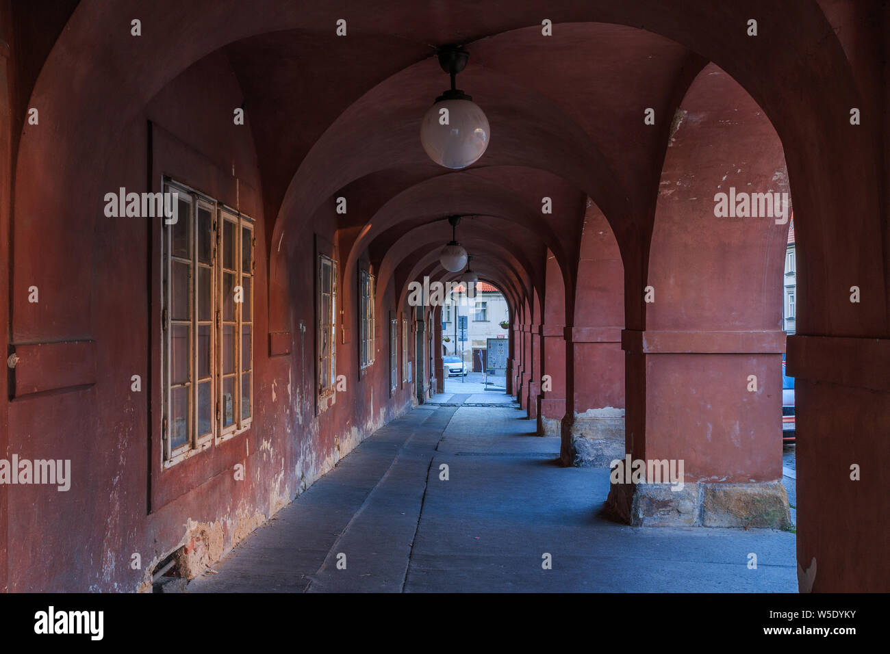 Lange gewölbte Haus in Rot mit Lampen an der Decke. Granit Bodenplatten und Sockel. Historischen Fenster an der Wand ohne Menschen in Prag Stockfoto