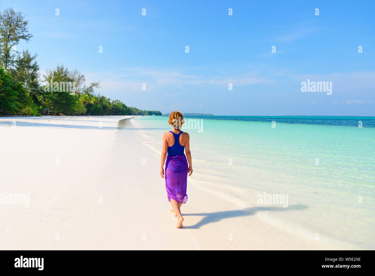 Frau Wandern am tropischen Strand. Ansicht der Rückseite White Sand Beach türkis durchsichtig Wasser Karibik reale Menschen. Indonesien Kei Inseln Molukken trave Stockfoto