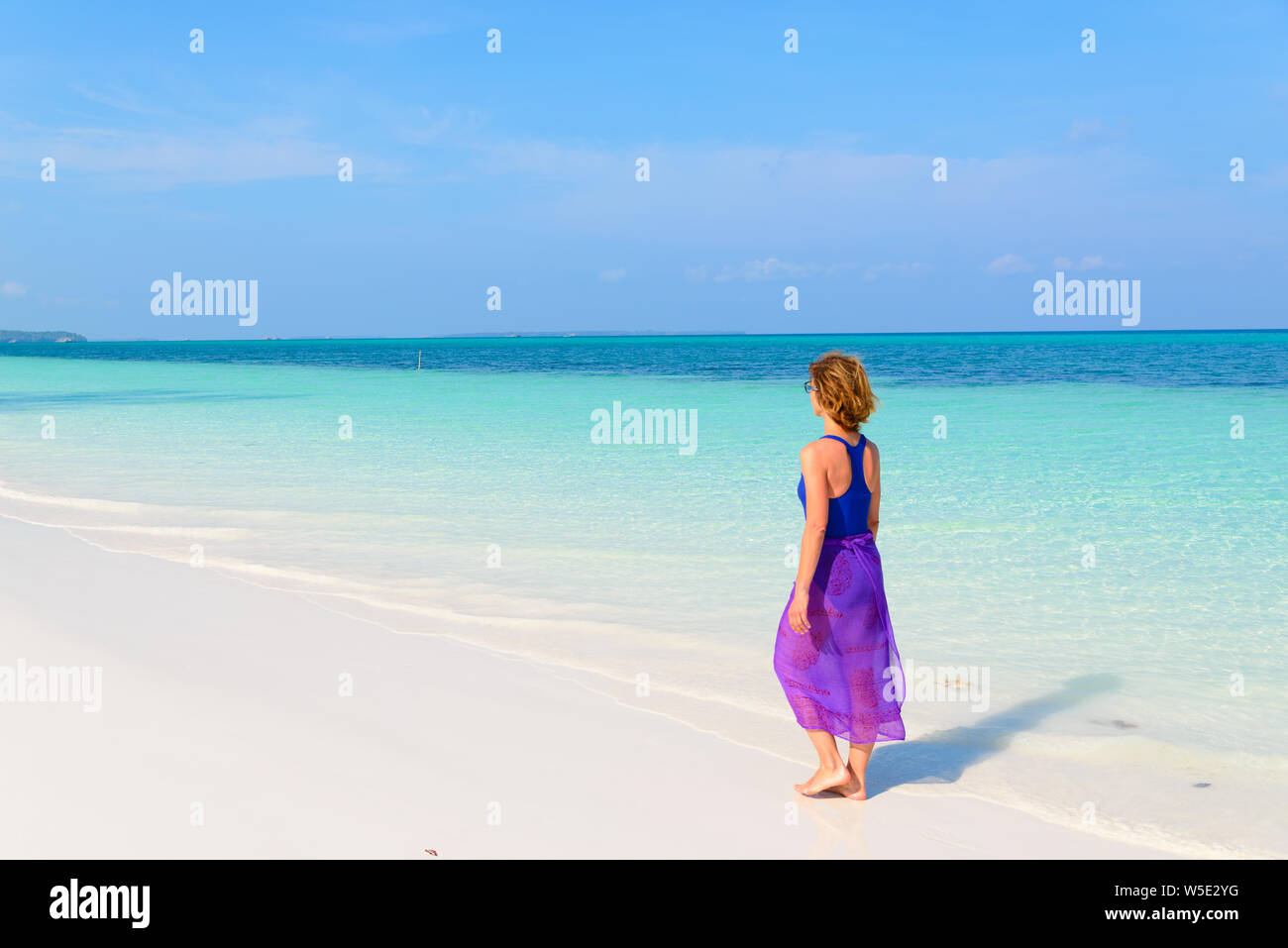 Frau Wandern am tropischen Strand. Ansicht der Rückseite White Sand Beach türkis durchsichtig Wasser Karibik reale Menschen. Indonesien Kei Inseln Molukken trave Stockfoto