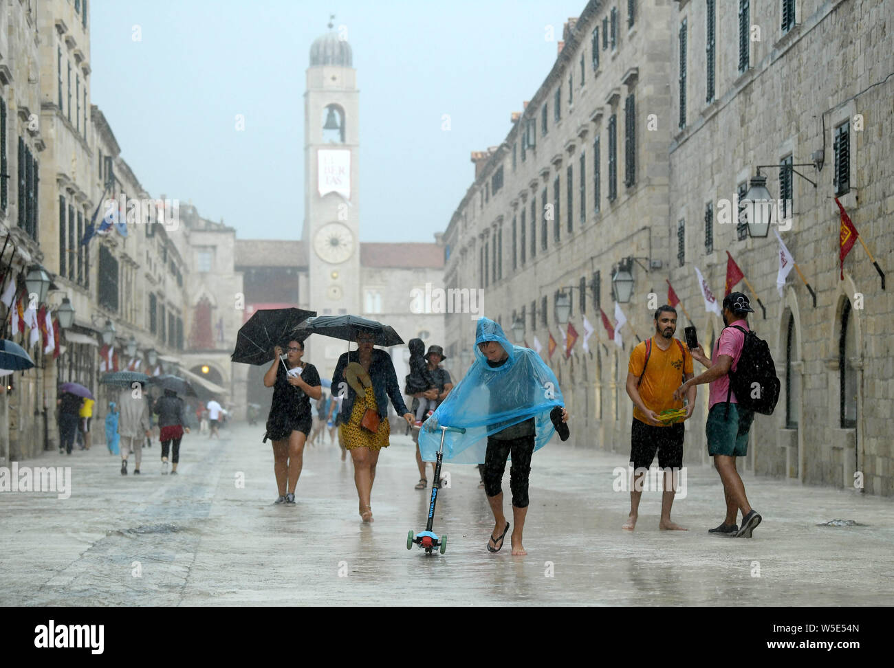 Dubrovnik, Kroatien. 28. Juli 2019. Menschen gehen auf die Straße der Altstadt von Dubrovnik, Kroatien, am 28. Juli 2019. Die bekanntesten touristischen Ziel wurde durch starken Regen und Gewitter am Sonntag getroffen. (Marko Lukunic/Pixsell über Xinhua) Quelle: Xinhua/Alamy leben Nachrichten Stockfoto