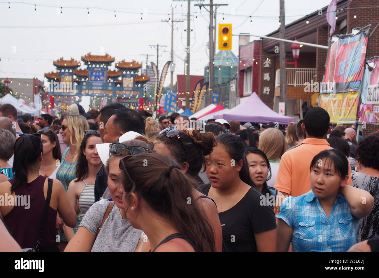 Fräsen Menge Szene an der Ottawa asiatischen Fest Nacht Markt, 2019. Ottawa, Ontario, Kanada. Chinatown Gateway im Hintergrund. Stockfoto