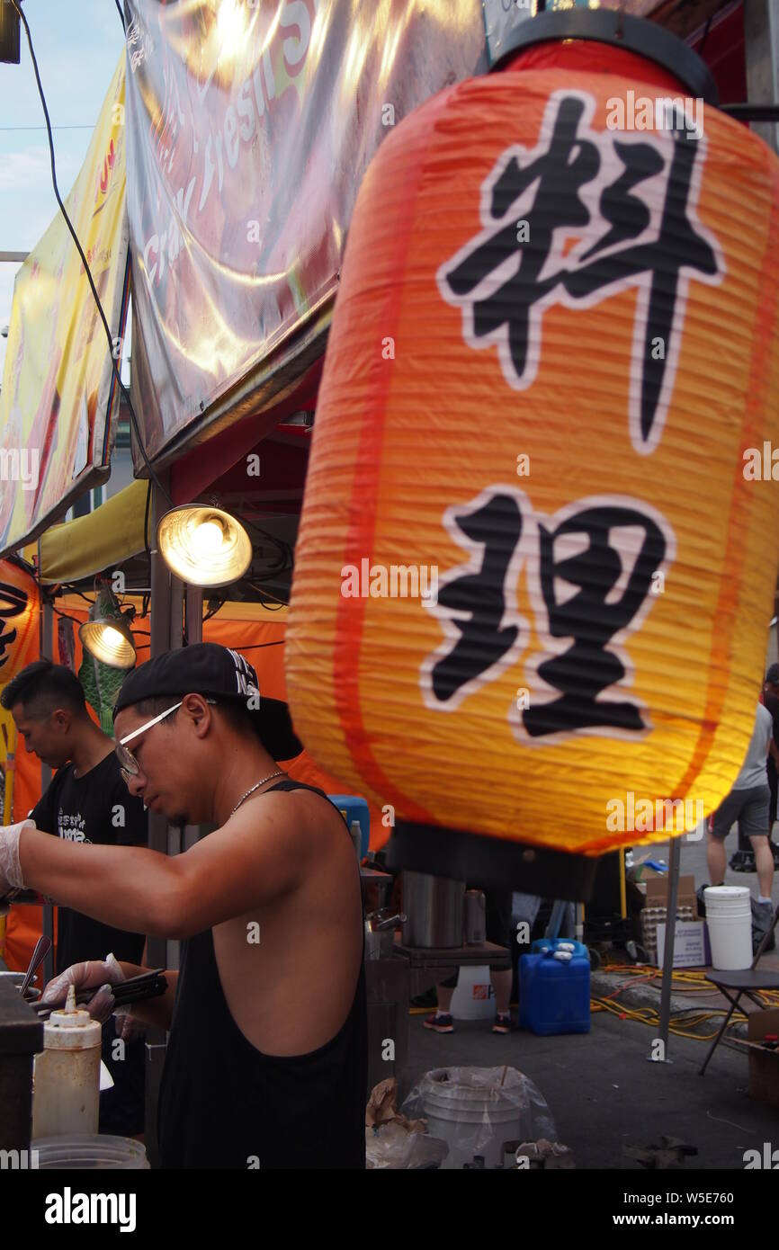 Zubereitung von Speisen unter einem großen Chinesische Laterne an der Ottawa asiatischen Fest Nacht Markt, 2019. Ottawa, Ontario, Kanada. Stockfoto