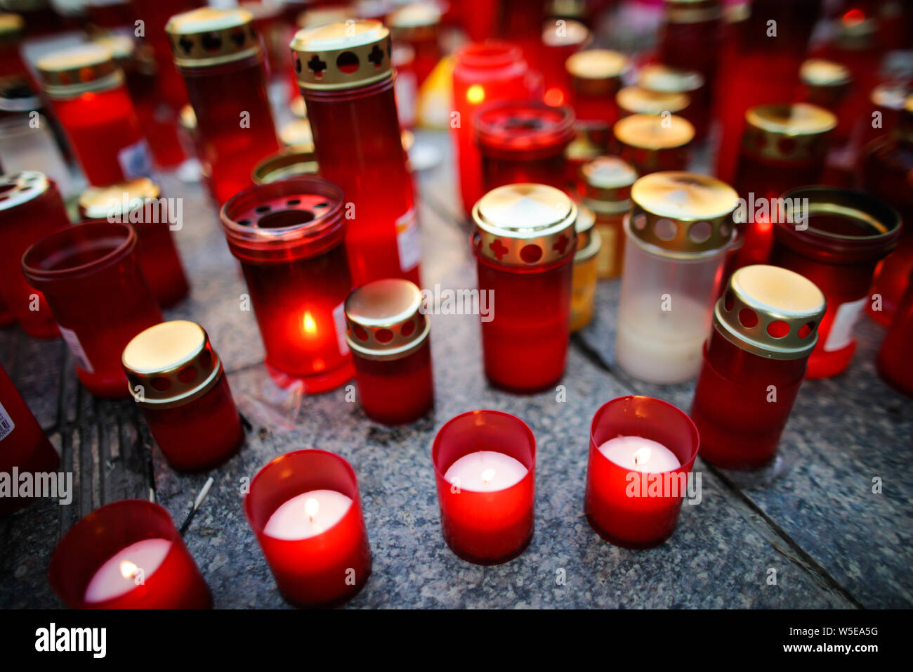 Flache Tiefenschärfe Bild mit Details der Kerzen auf dem Bürgersteig durch Menschen Stockfoto