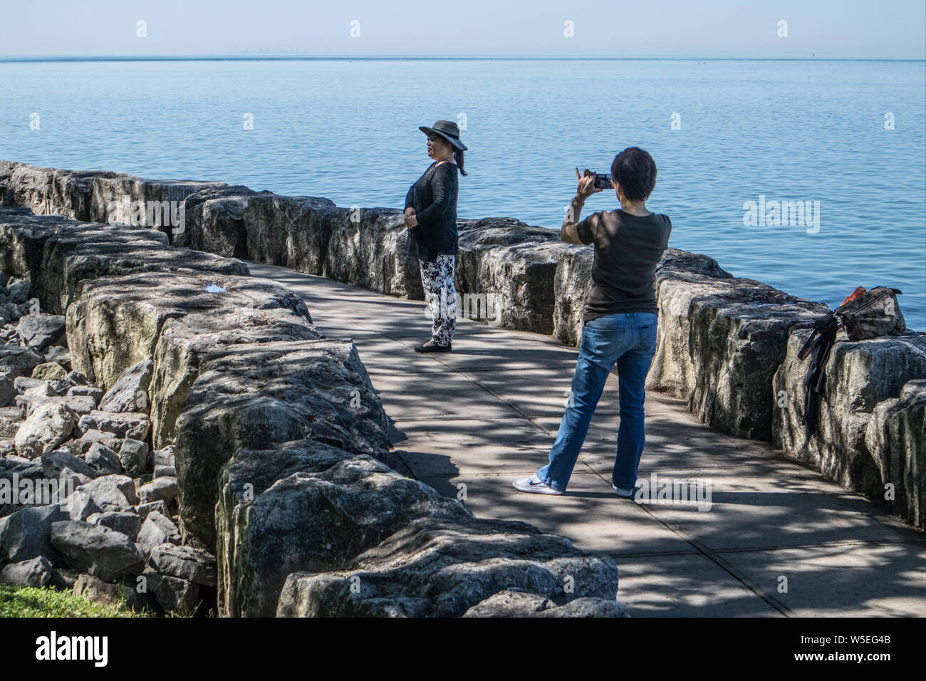 Auf den Spuren am Ontario See am Niagara On The Lake, zwei junge asiatische Frauen. Nimmt man die Bild des Anderen. Sie nimmt lustige Posen.. Stockfoto