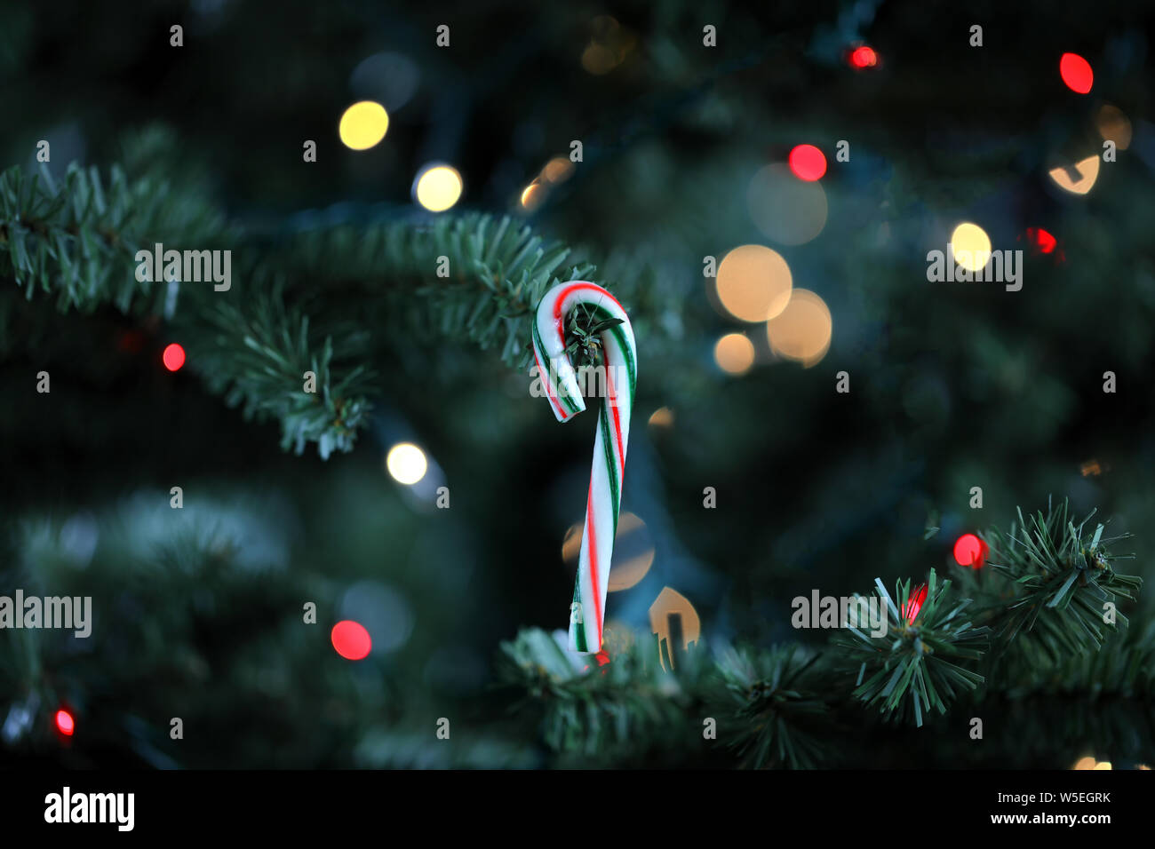 Traditionelle künstlicher Weihnachtsbaum mit Zuckerstange Ornament und glühenden Lichter im Hintergrund Stockfoto