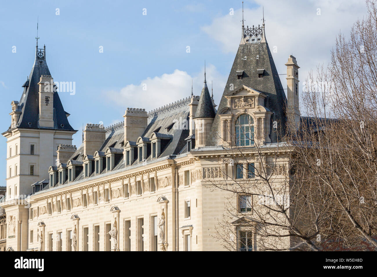 Das Palais de Justice de Paris auf der Ile de la Cite, sunlit gegen einen dunklen Himmel Stockfoto