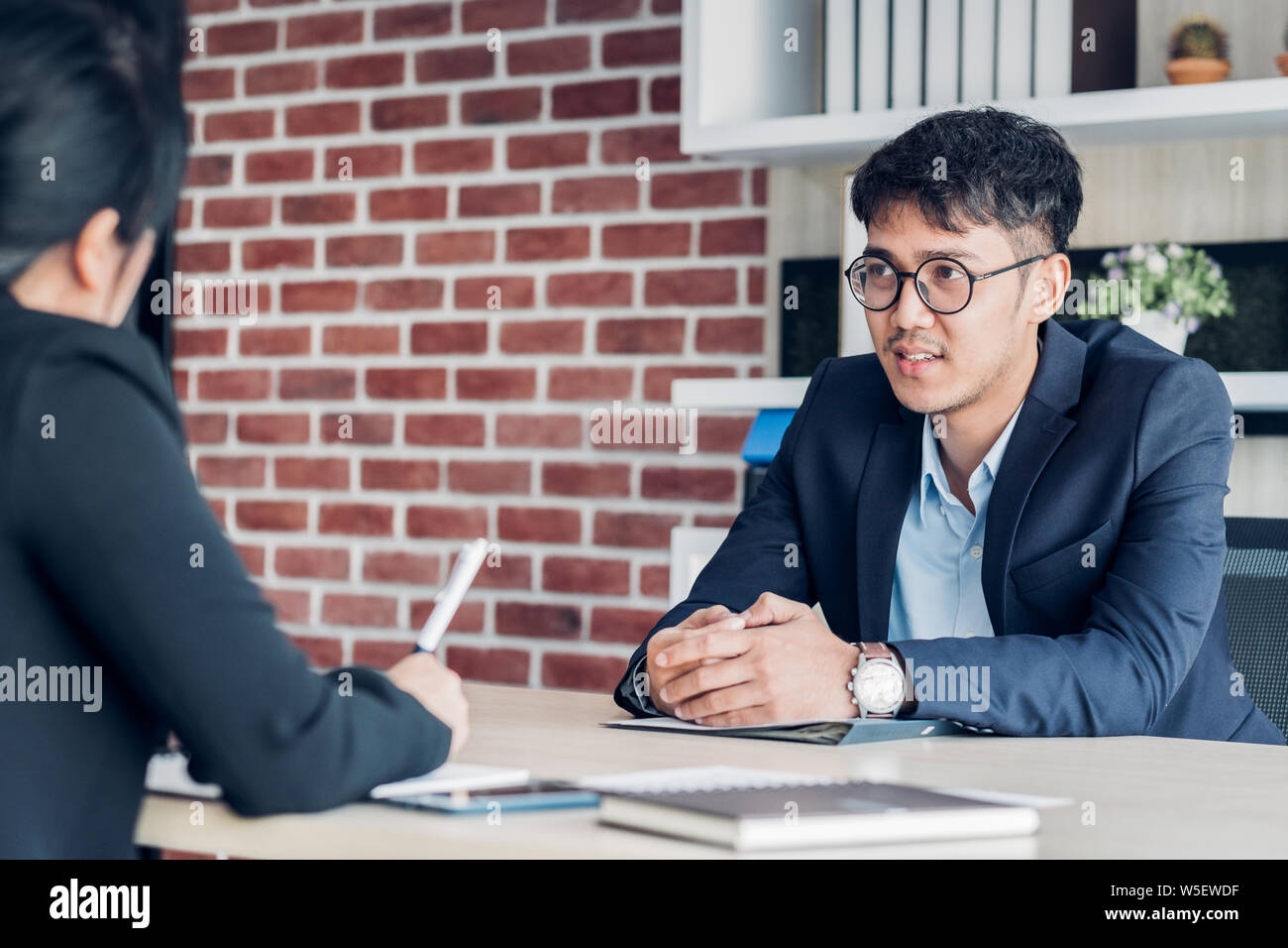 Junge asiatische Geschäftsmann und Geschäftsfrau Sprechen über business-Vereinbarung in der Sitzung Tabelle in modernen Büro. Business Partnership Konzept. zufrieden. Stockfoto