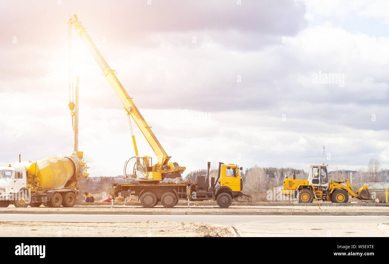 Bau einer neuen Straße und die Installation von strassenlaternen mit einem Lkw-Kran und Betonmisch-LKW, Arbeitnehmer, Kopie, Beruf, Lader Stockfoto