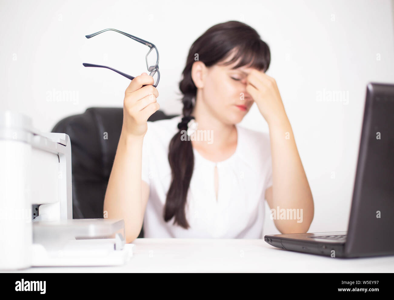 Mädchen business Arbeiter im Büro hält Gläser in der Hand. Konzept der Schmerz in den Augen von dem Computer, Dry Eye Syndrome, Unterkunft Spasmus, eyegla Stockfoto