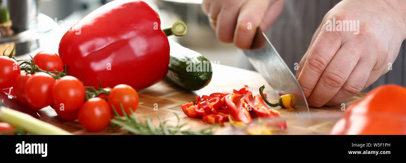 Professionelle kulinarische Mann Schneiden Hot Chili Pfeffer Stockfoto