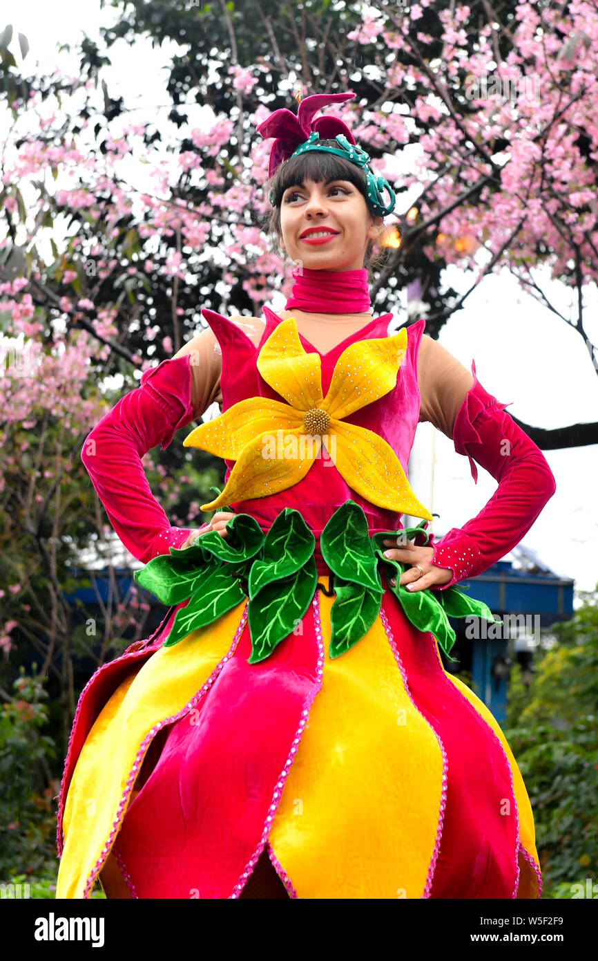 Ein Entertainer gekleidet in einem bunten Rock mit Blumen dekoriert, stellt auf der Guangzhou Chimelong Tourist Resort in der Stadt Guangzhou, Südchina Gua Stockfoto