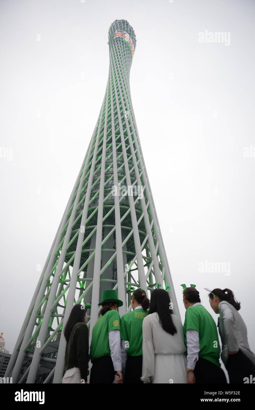 Darsteller Tanz der Saint Patrick's Day vor der Kanton Turm, ein Wahrzeichen in Guangzhou zu feiern, gebadet in grün in Guangzhou City, South Stockfoto