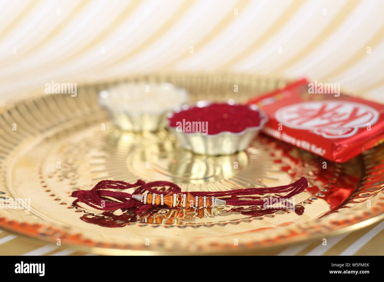 Indian Festival: Raksha Bandhan Hintergrund mit einem eleganten Rakhi, Reis Körner und Kumkum. Ein traditionelles indisches Armband, ist ein Symbol der Liebe. Stockfoto