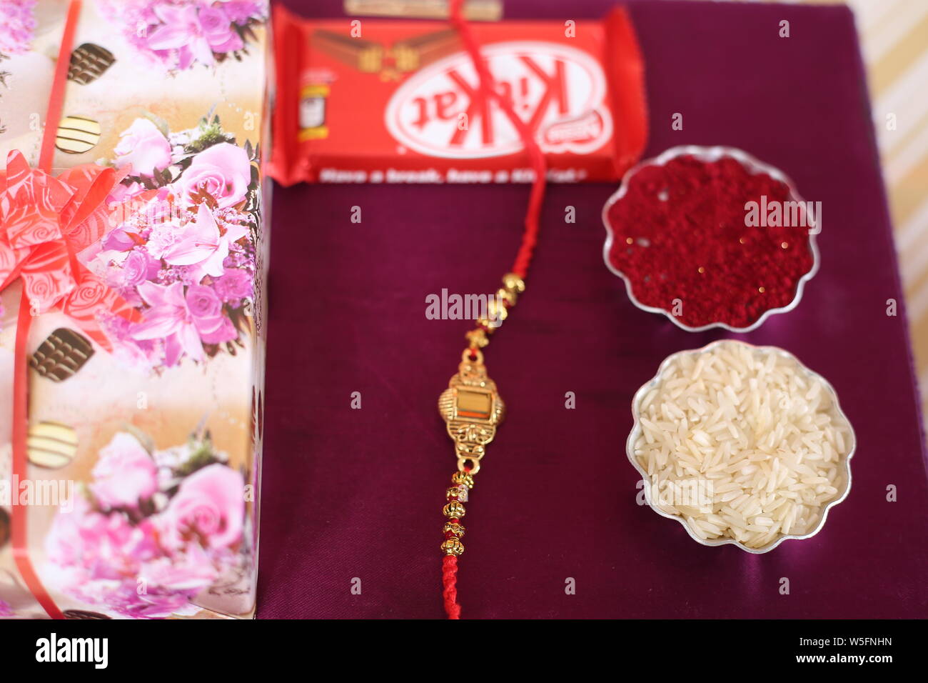 Indian Festival: Raksha Bandhan Hintergrund mit einem eleganten Rakhi, Reis Körner und Kumkum. Ein traditionelles indisches Armband, ist ein Symbol der Liebe. Stockfoto