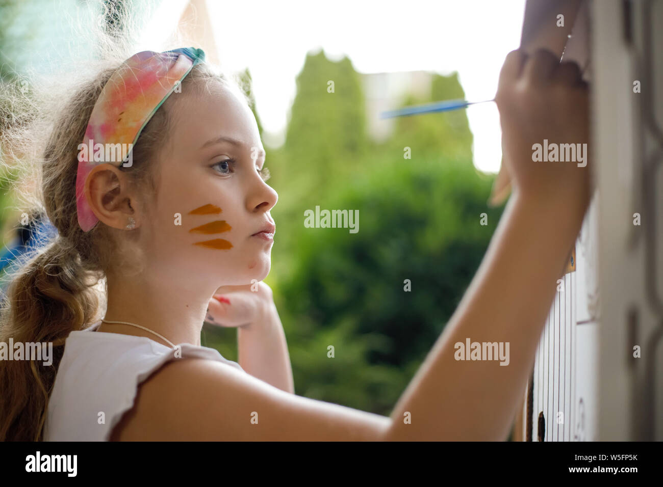 Mädchen malt eine Pappe Haus am Sommer, Tag, Outdoor. Stockfoto