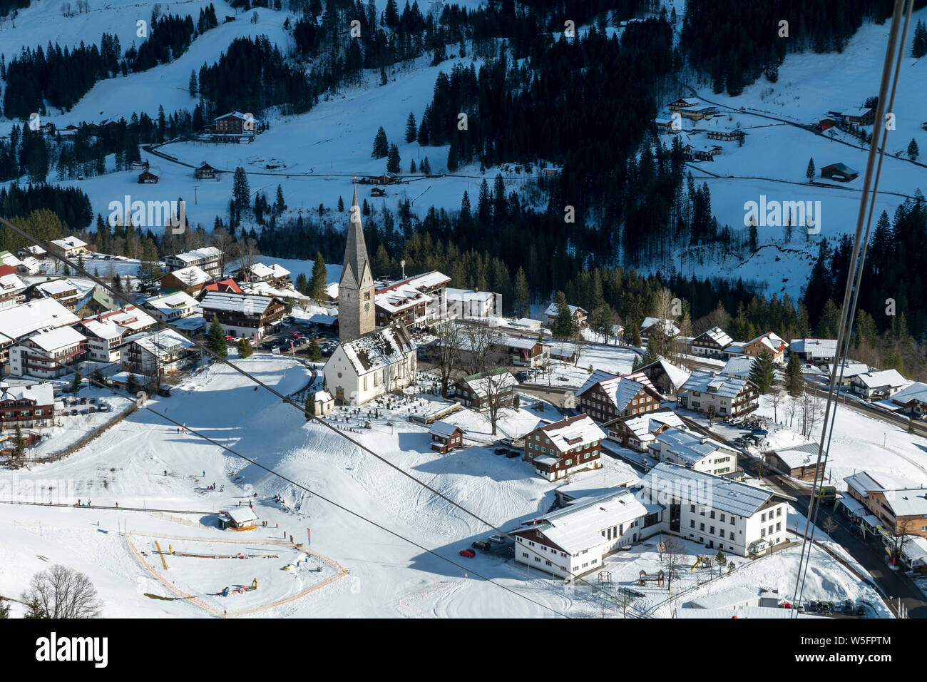 Österreich, Kleinwalsertal (Kleines Walsertal), Allgäuer Alpen, Seilbahn (nach unten) - Walmendinger Horn (1990 m), Mittelberg Alpine Village, Pfarrkirche St. Jodok Stockfoto