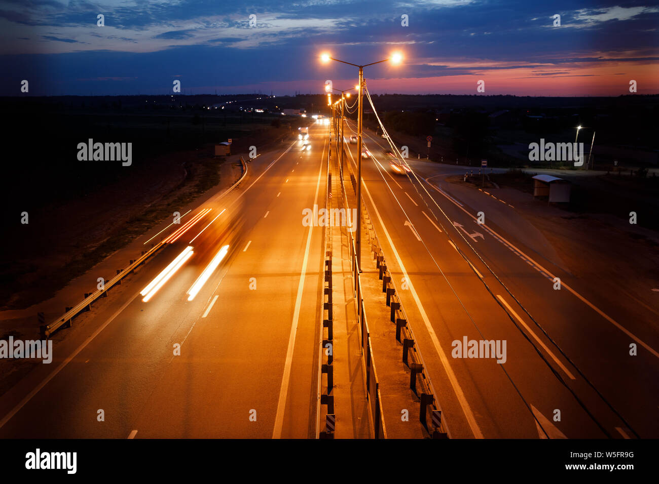 Der Verkehr auf der Autobahn in der Dämmerung. Stockfoto