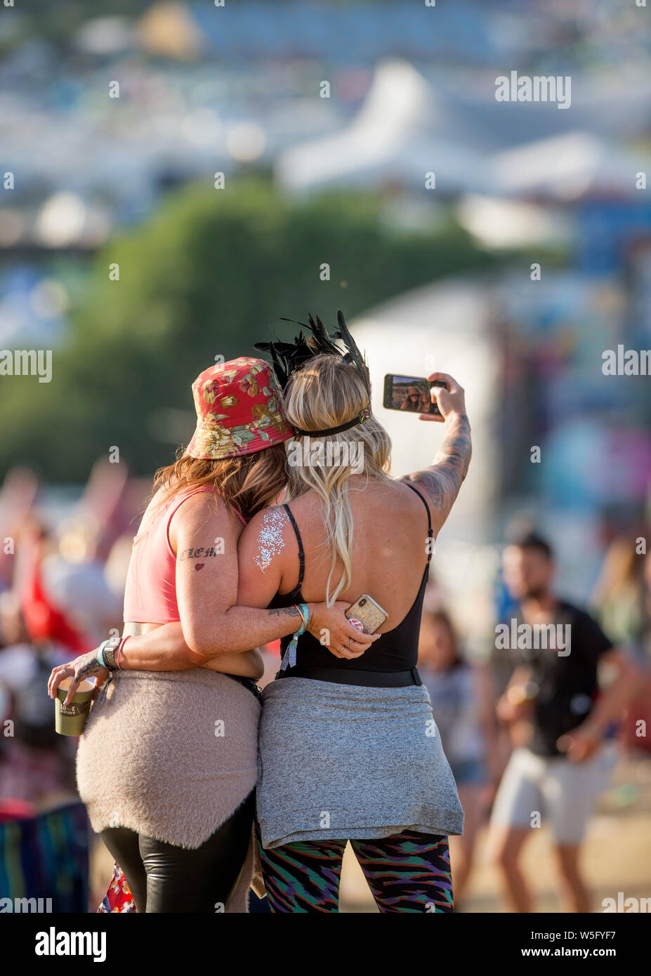 Zwei Frauen nehmen einen selfie im Park auf dem Glastonbury Festival 2019 in Pilton, Somerset Stockfoto