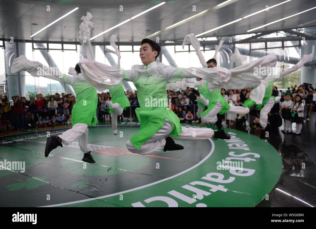 Darsteller Tanz der Saint Patrick's Day vor der Kanton Turm, ein Wahrzeichen in Guangzhou zu feiern, gebadet in grün in Guangzhou City, South Stockfoto