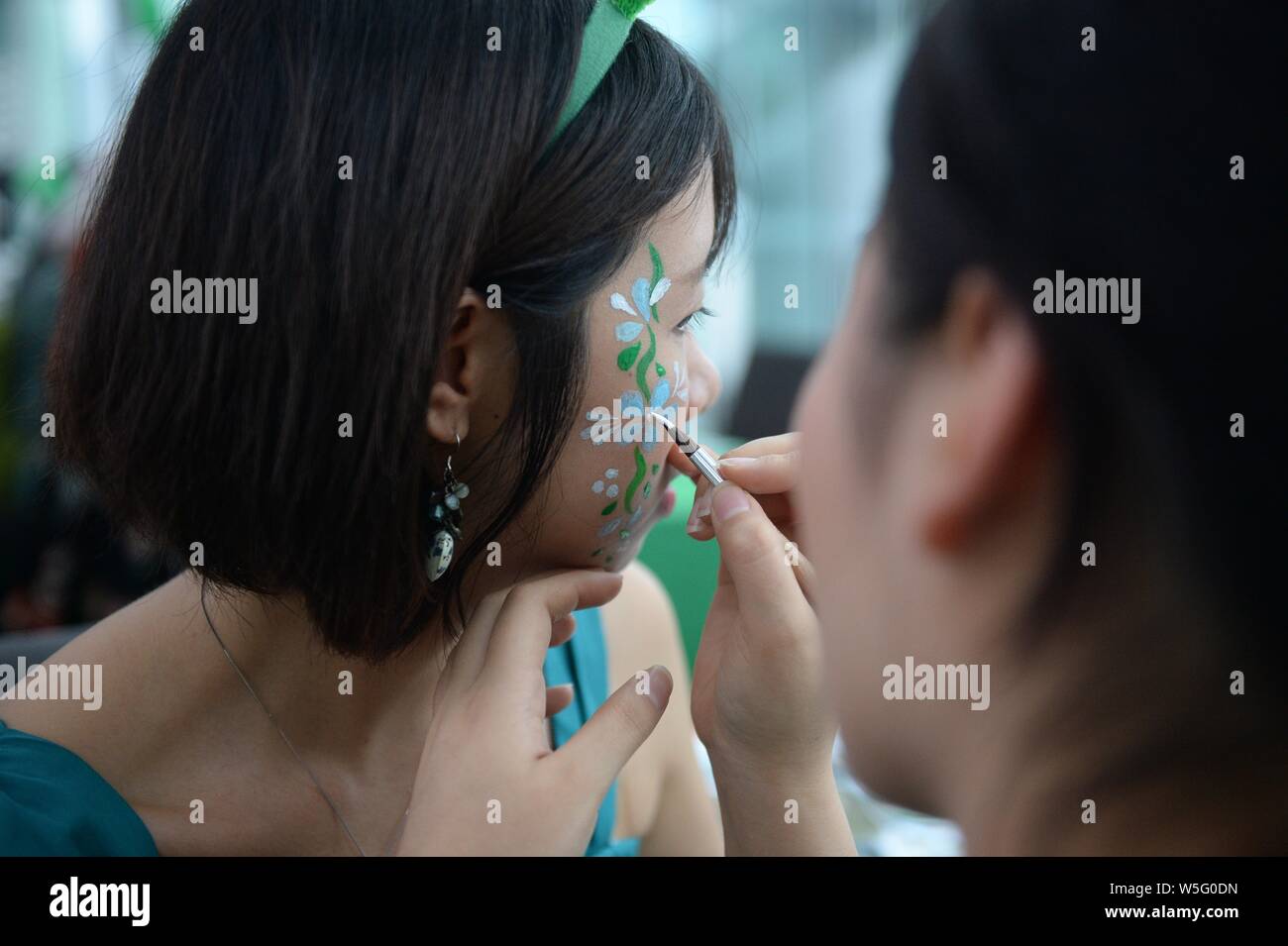 Ein performer beendet Make-up die Saint Patrick's Day vor der Kanton Turm, ein Wahrzeichen in Guangzhou zu feiern, gebadet in grün in Guangzhou c Stockfoto
