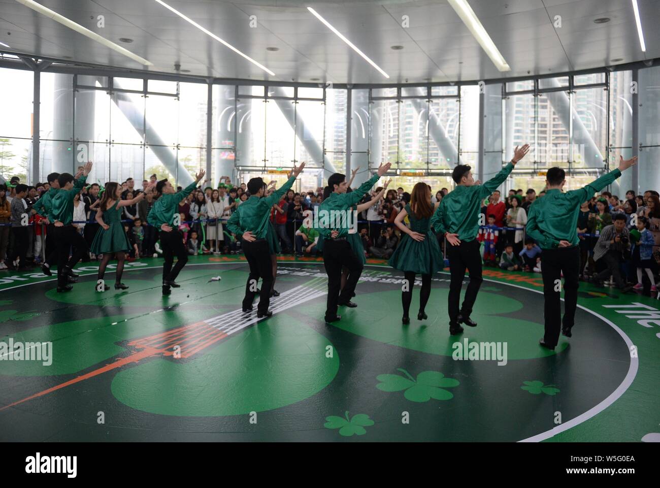 Darsteller Tanz der Saint Patrick's Day vor der Kanton Turm, ein Wahrzeichen in Guangzhou zu feiern, gebadet in grün in Guangzhou City, South Stockfoto