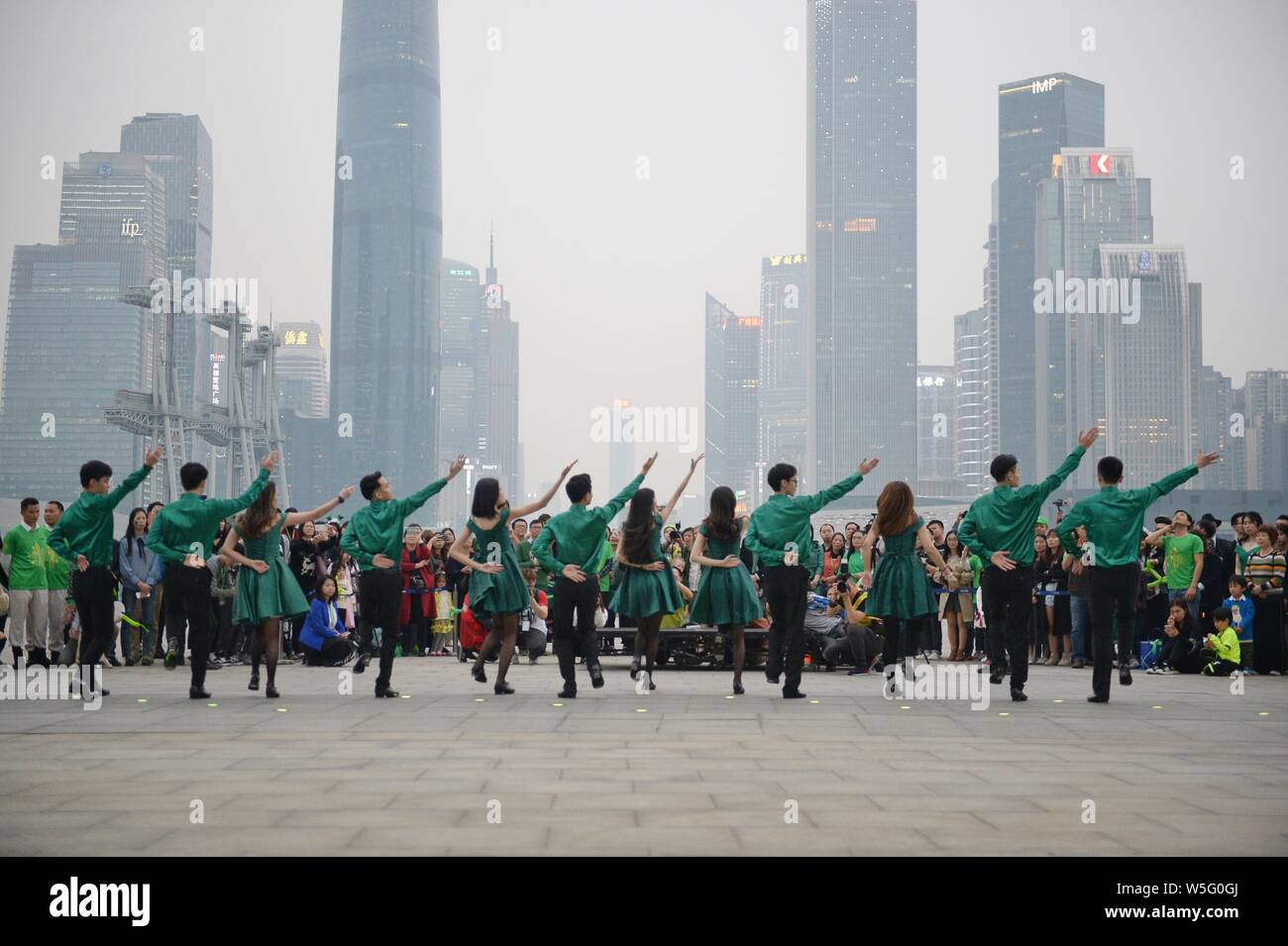 Darsteller Tanz der Saint Patrick's Day vor der Kanton Turm, ein Wahrzeichen in Guangzhou zu feiern, gebadet in grün in Guangzhou City, South Stockfoto