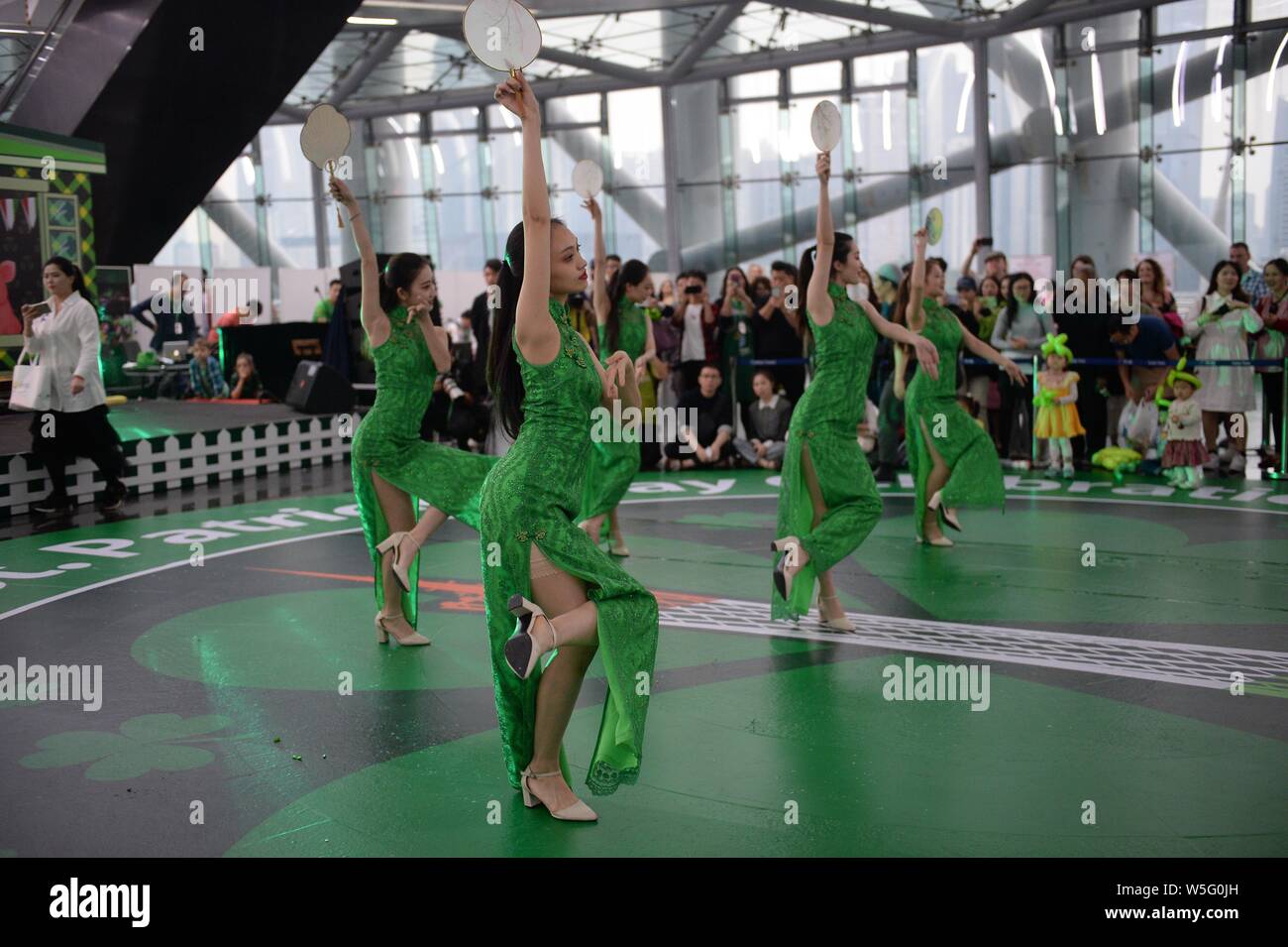 Darsteller Tanz der Saint Patrick's Day vor der Kanton Turm, ein Wahrzeichen in Guangzhou zu feiern, gebadet in grün in Guangzhou City, South Stockfoto