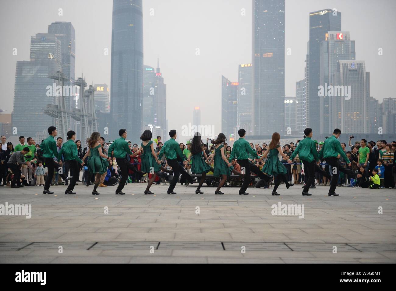 Darsteller Tanz der Saint Patrick's Day vor der Kanton Turm, ein Wahrzeichen in Guangzhou zu feiern, gebadet in grün in Guangzhou City, South Stockfoto