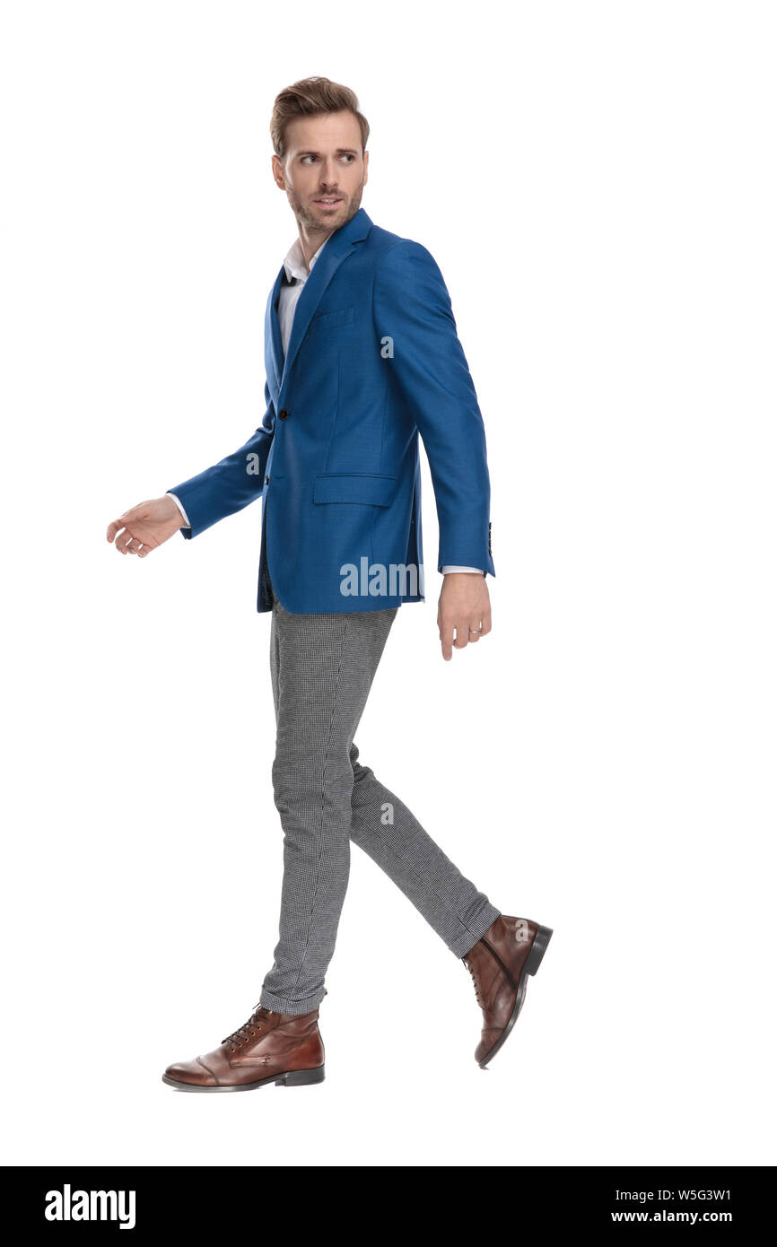 Betroffenen legerer Mann über die Schulter schauen und wandern an der Seite während wearign einen Anzug auf der weißen studio Hintergrund Stockfoto