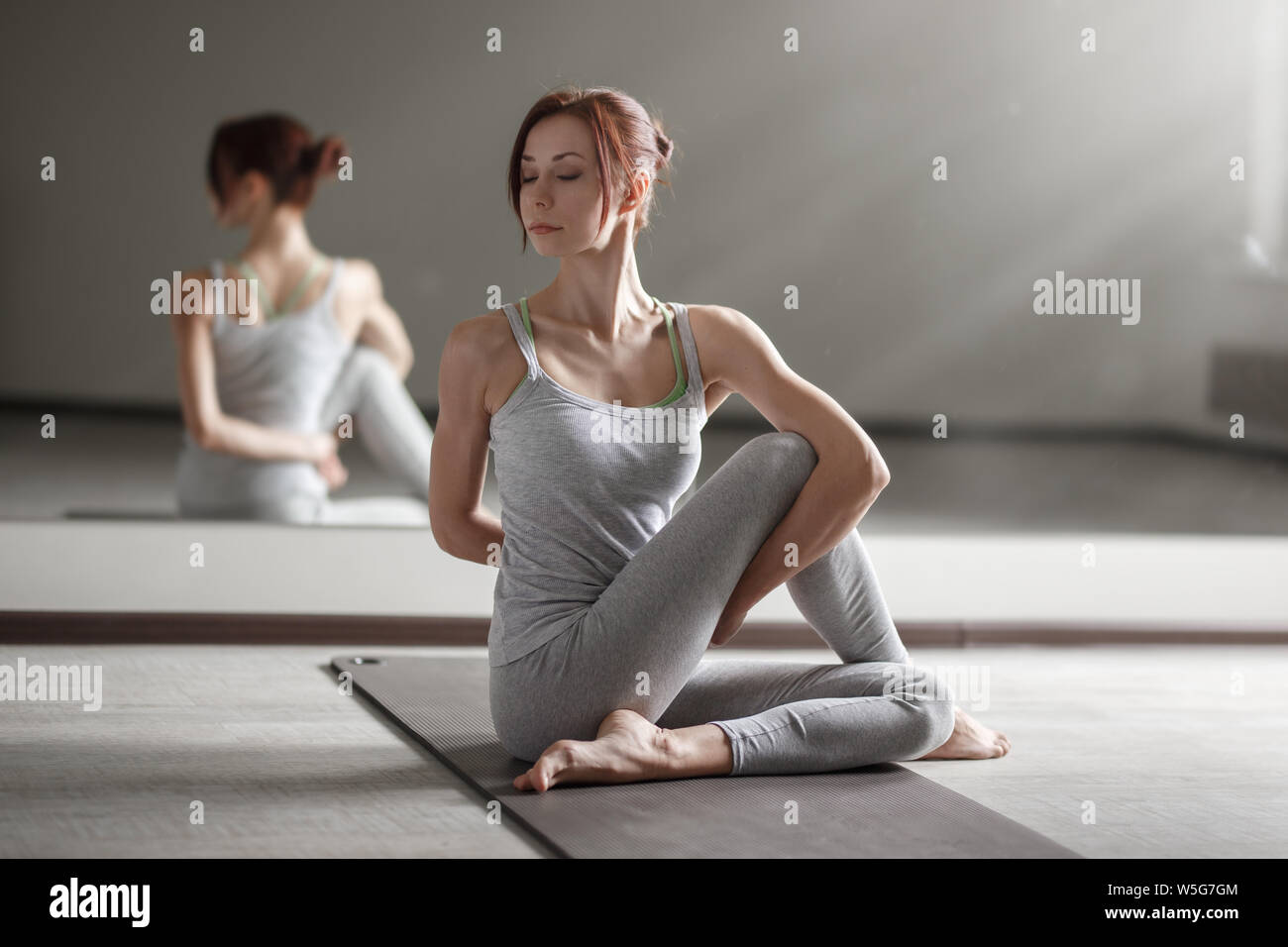 Junge Frau mit Yoga in hellen Zimmer Schöne asana Übungen. Stockfoto