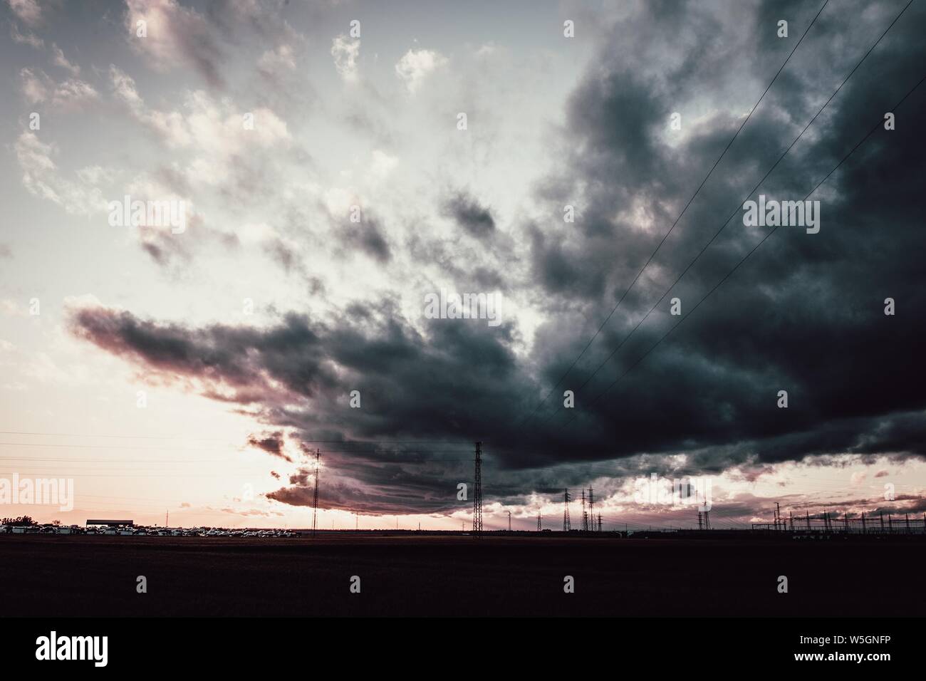 Lange Aufnahme eines dunklen bewölkten Himmels über Antennentürmen Stockfoto