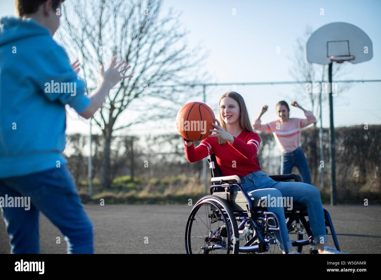 Teenage Mädchen im Rollstuhl Basketball spielen mit Freunden Stockfoto