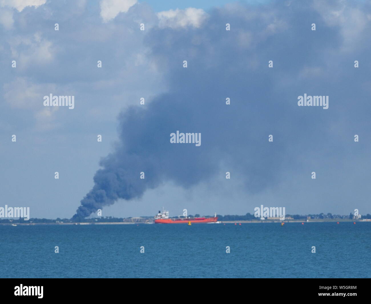 Sheerness, Kent, Großbritannien. 29. Juli, 2019. Ein großer Brand in Essex als über vom Wasser in Sheerness, Kent gesehen. Update: Brand glaubten an Towerfield Straße, shoebury an Verpackung ab Werk. Rund 50 Feuerwehrleute mit der Flamme. Credit: James Bell/Alamy leben Nachrichten Stockfoto