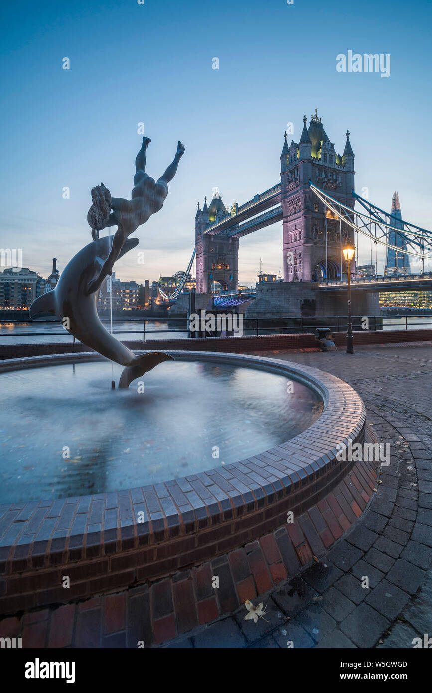 Mädchen mit Dolphin Fountain und Tower Bridge bei Nacht, Katharinenkirche und Wapping, London, England, Vereinigtes Königreich, Europa Stockfoto