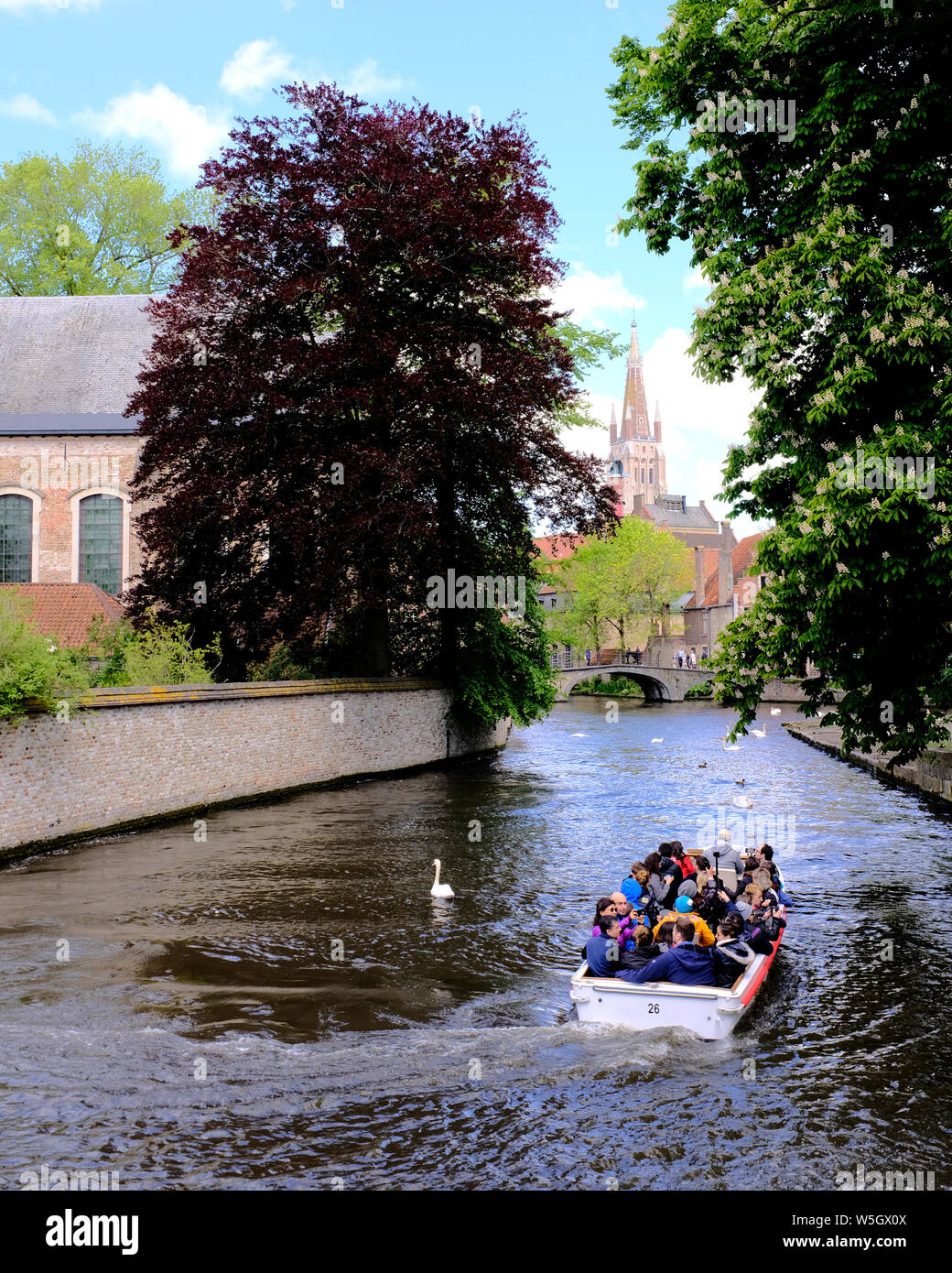 Touristische Bootsfahrt auf den Kanälen von Brügge mit der Frauenkirche im Hintergrund, Brügge, Belgien, Europa Stockfoto