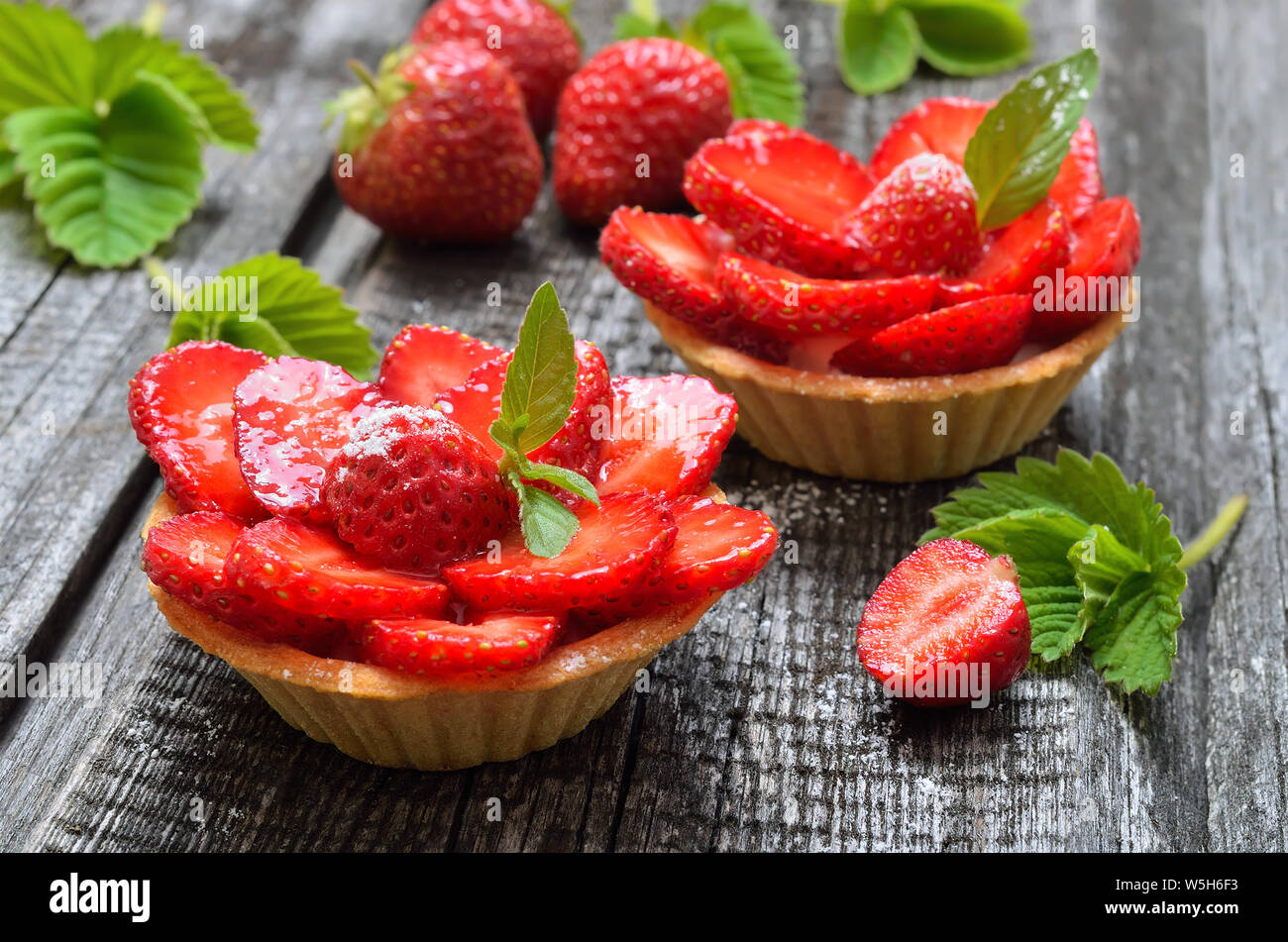 Törtchen mit frischen Erdbeeren auf hölzernen Hintergrund Stockfoto