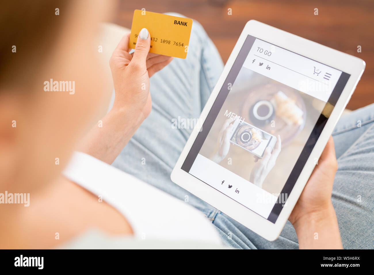Moderne Verbraucher mit Plastikkarte und Tablet Schauen durch on-line-Waren Stockfoto