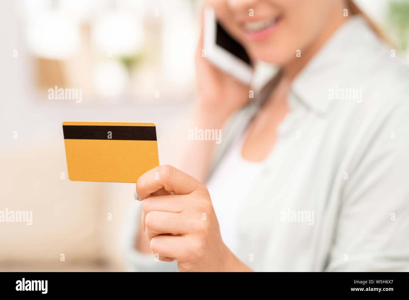 Gelbe Plastikkarte mit schwarzen magnet Linie in der Hand der jungen weiblichen Verbraucher Stockfoto