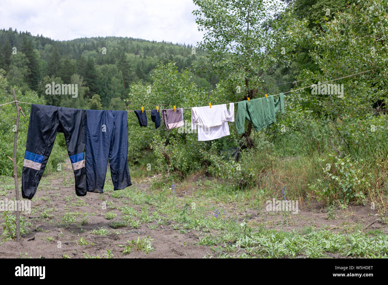 Seil mit nassen Kleidern in der Open Air im Lager. Touristische leben - Kleidung in der offenen Luft getrocknet. Im Regen getränkt Stockfoto