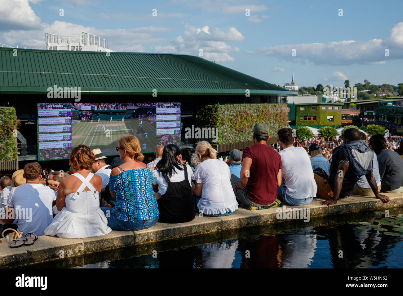 Fans und Zuschauer auf Henman Hill, Murray Damm oder Aorangi Hügel mit dem großen Bildschirm auf Nr. 1 Gericht während der Meisterschaften in Wimbledon 2019. Stockfoto