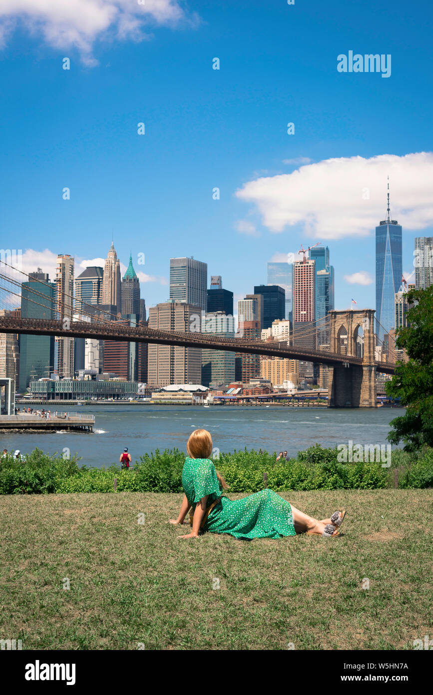 New York Skyline, Ansicht der Rückseite einer Frau, die sich in der Main Street Park, Brooklyn, am unteren Skyline von Manhattan, New York City suchen. Stockfoto