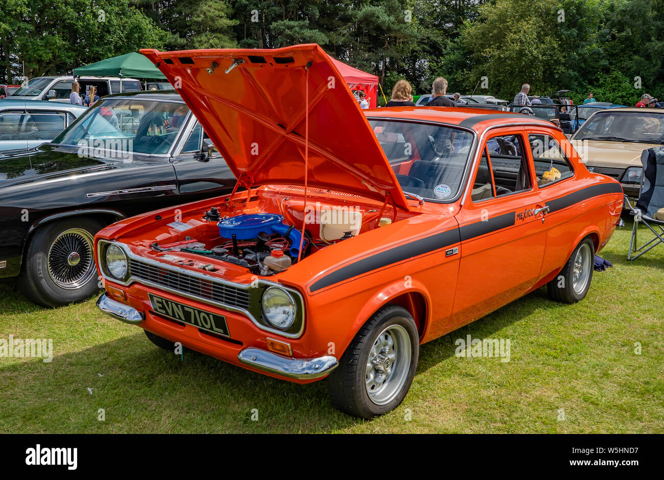 Seitenansicht einer orange Ford Mexiko Replik Rally Car mit angehobener Motorhaube auf Anzeige an das jährliche Oldtimertreffen in Wroxham, Norfolk, Großbritannien Stockfoto