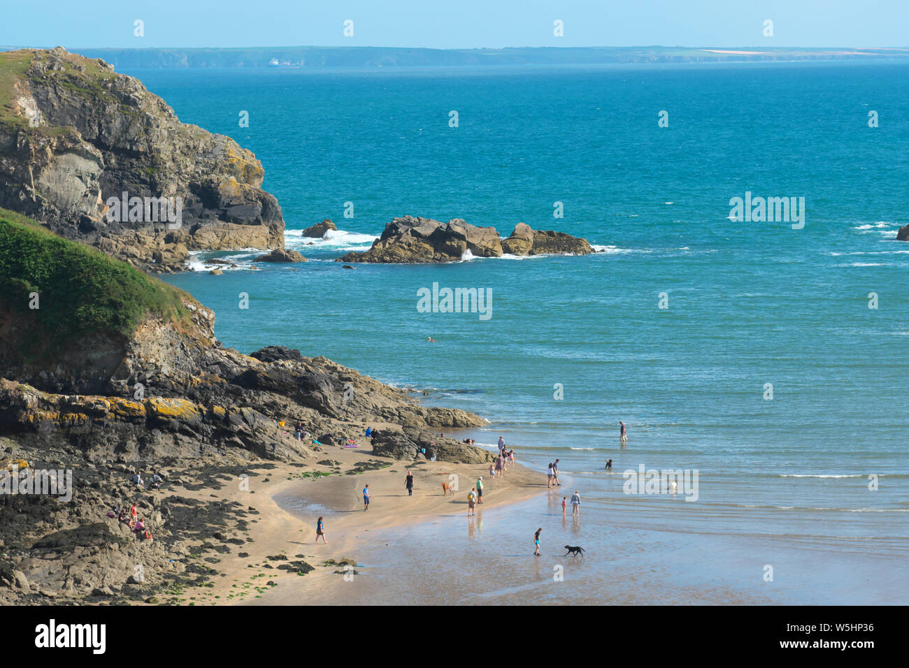 Solva, Pembrokeshire, Wales, UK Besucher Paddel am Strand bei Ebbe im Sommer Juli 2019 Stockfoto