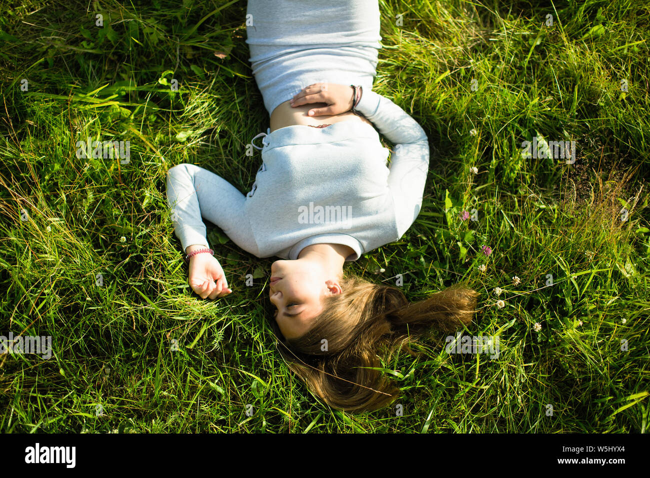 Im oberen Bild eines jungen Mädchens in das grüne Gras liegen. Stockfoto