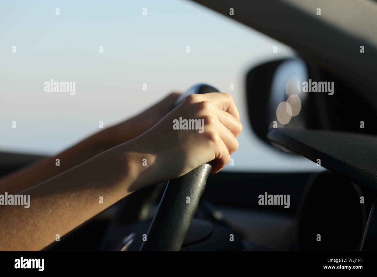 Nahaufnahme von einem Fahrer Hände halten Lenkrad Auto fahren Stockfoto