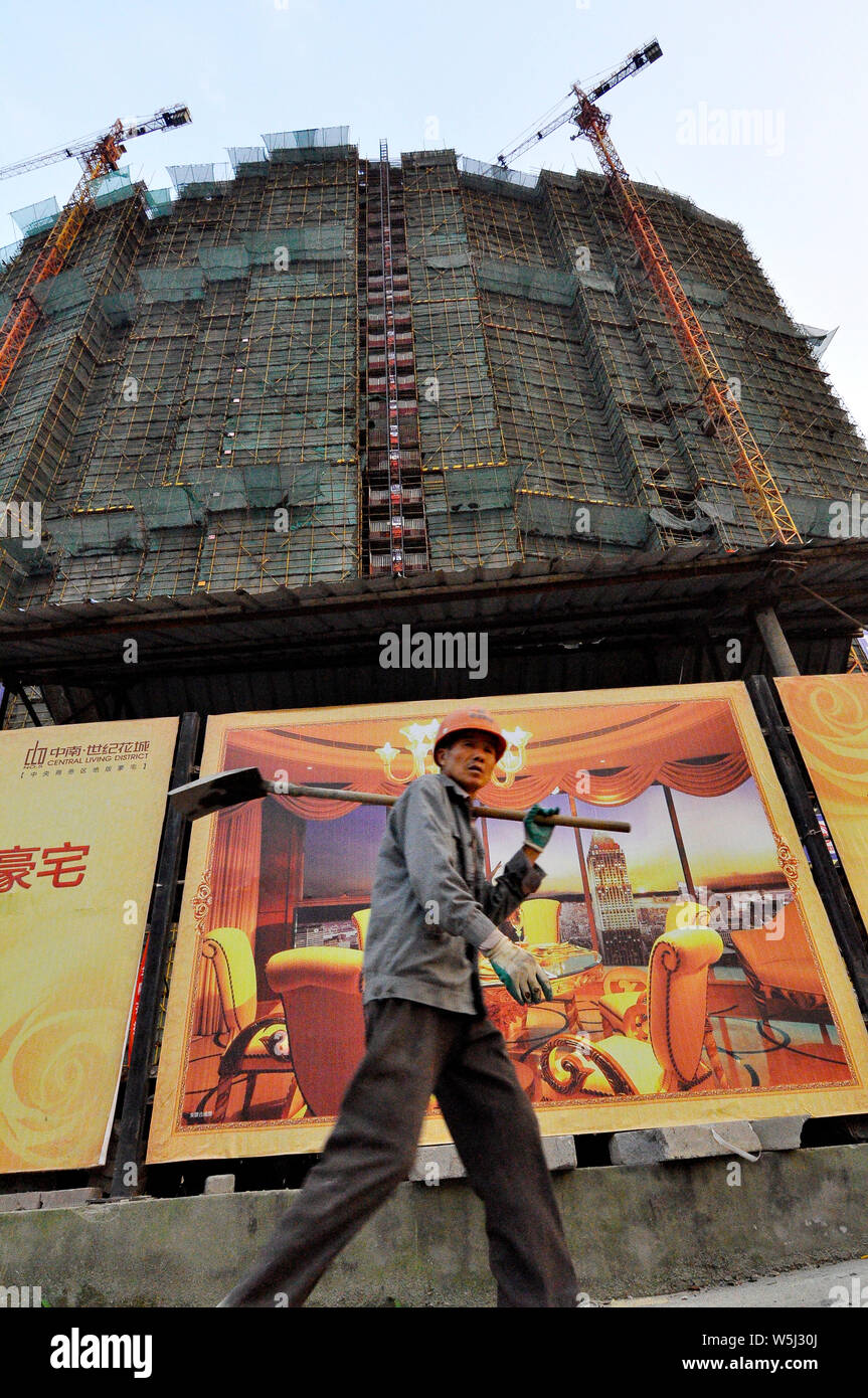 Ein wanderarbeitnehmer Spaziergänge Vor ein Luxus apartment Poster und Entwicklung in Nantong China Stockfoto
